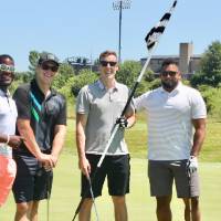 football alumni hold golf flag before they get their ball